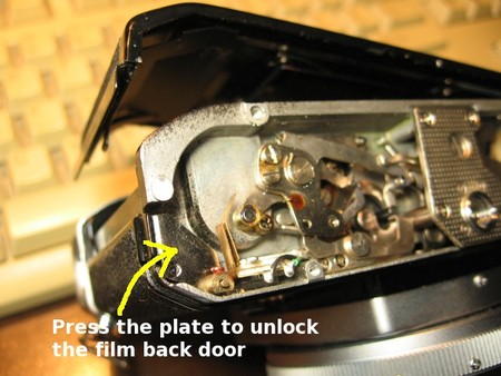 The part of the spring lock under the camera used to open the film door.